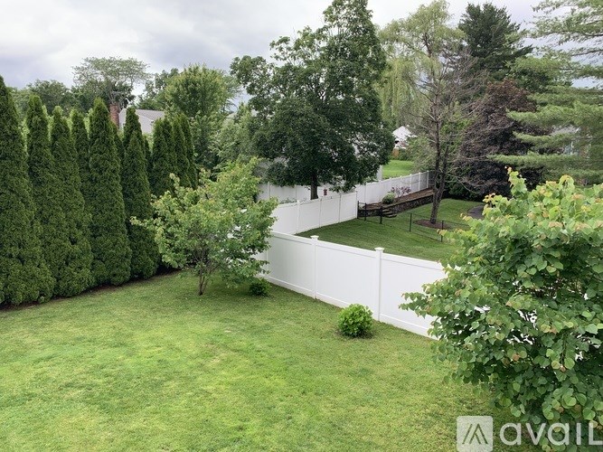 A white fence encloses a lush green yard.