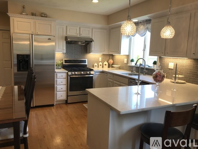A kitchen with a refrigerator, oven, and sink.