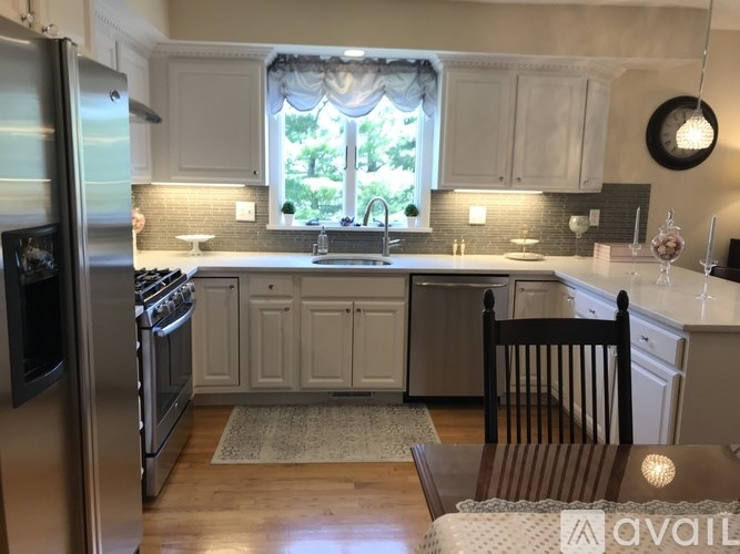 A kitchen with white cabinets and a wooden table.