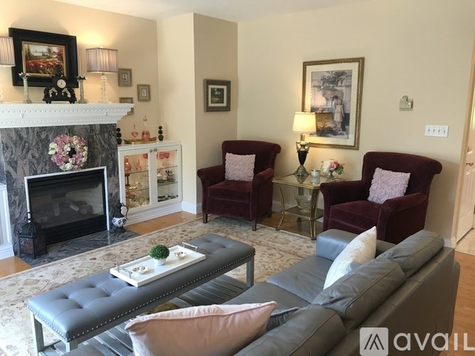 A living room with a fireplace, two chairs, a couch, and a coffee table.