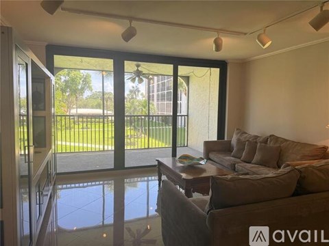 A living room with a couch and a fan.