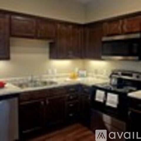 A kitchen with dark wood cabinets and a white counter.