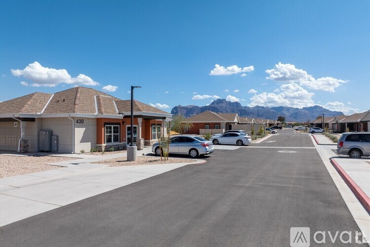 A street view of a residential area with houses and parked cars.