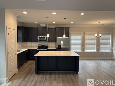 A modern kitchen with black cabinets and a wooden island.
