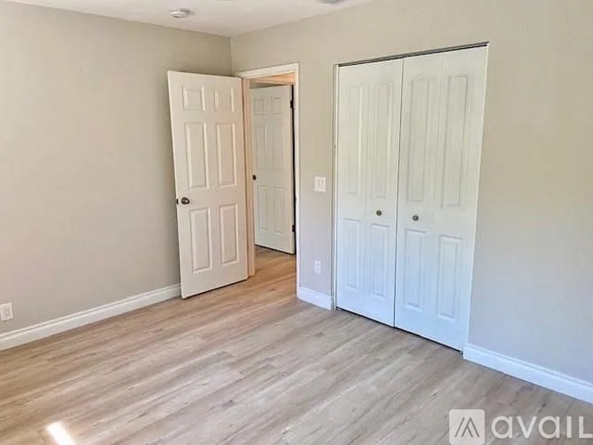 A room with a white door and a white closet with a sign that says "available".