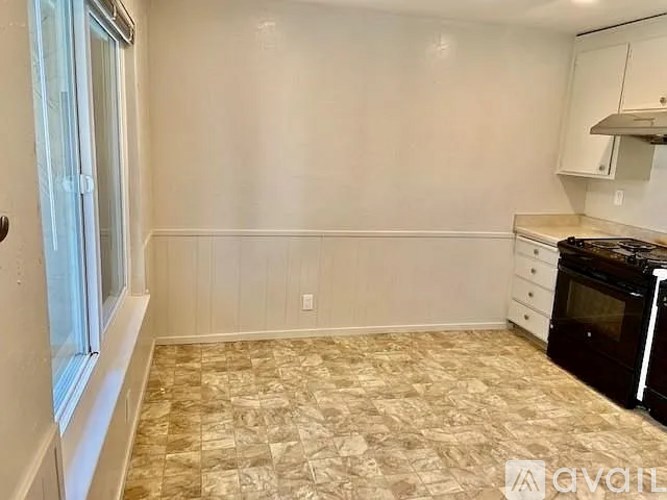 A kitchen with a tiled floor and a stove top oven.