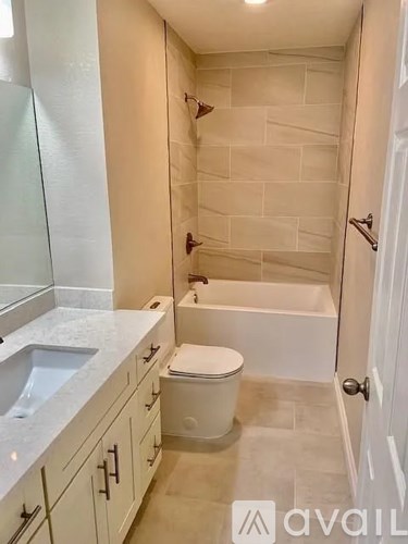 A bathroom with a toilet, sink, and bathtub.