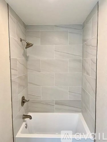 A white bathroom with a white tub and a white shower.