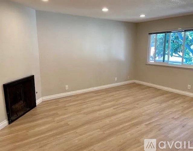 A room with a fireplace and wooden flooring.