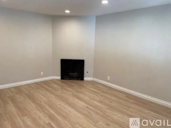 A room with a fireplace and wooden flooring.
