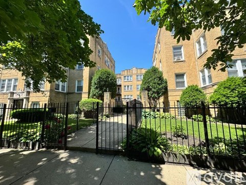 A black metal gate blocks the entrance to a sidewalk.
