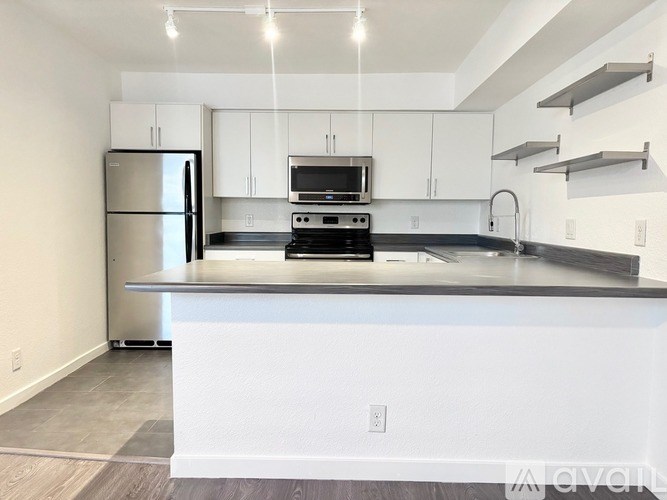 A modern kitchen with white cabinets and stainless steel appliances.