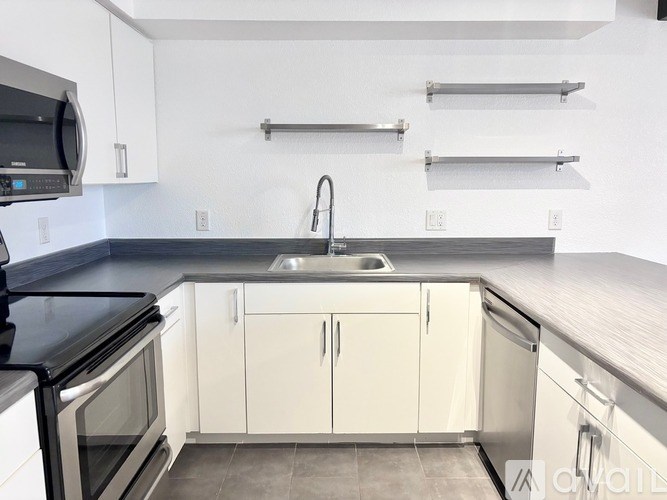 A kitchen with white cabinets and a black countertop.
