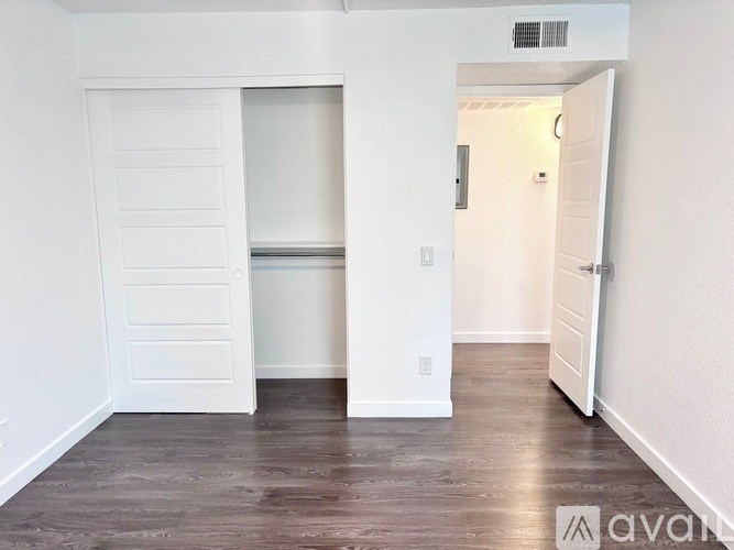 A white door with a shelf underneath it in a room with wooden floors.