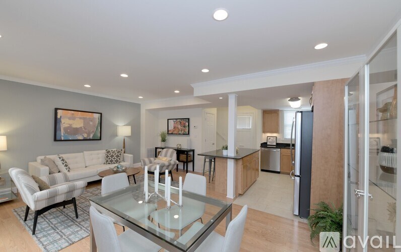 A modern living room with a glass dining table and chairs.