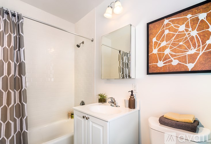 A bathroom with a white sink and a large mirror.