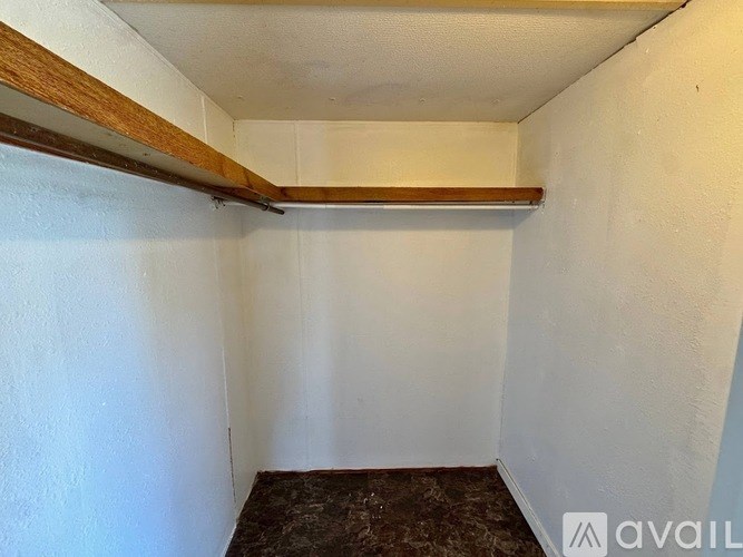 A small, empty room with a wooden beam on the ceiling.