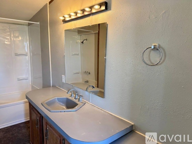 A bathroom with a sink, mirror, and lights above it.