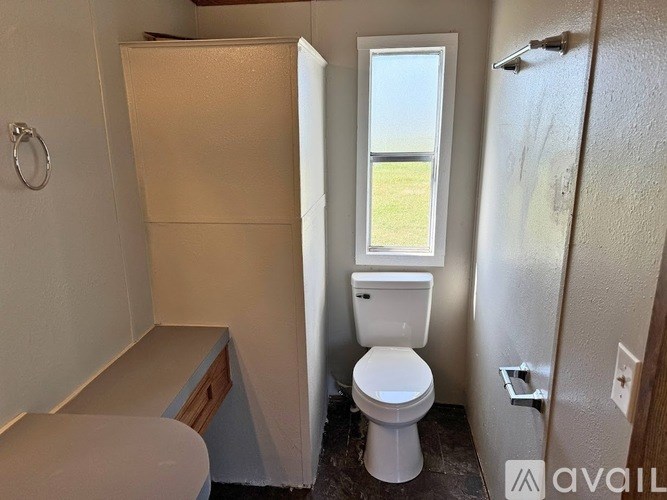 A small bathroom with a toilet, sink, and a window.