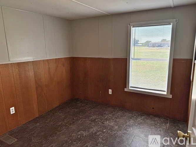 A room with wooden walls and a window with blinds.