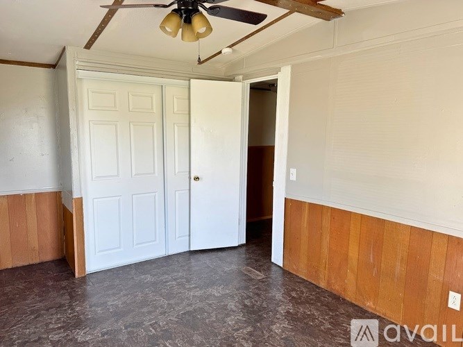 A room with a ceiling fan and two doors.