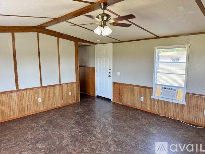 A room with a ceiling fan and a window with blinds.