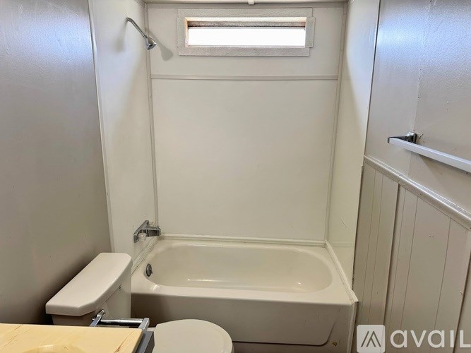 A white bathroom with a toilet, sink, and bathtub.