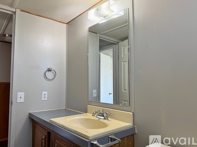 A bathroom with a sink, mirror, and light switch.