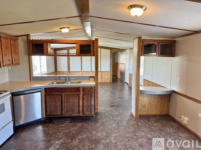 A kitchen with a sink, stove, and cabinets.