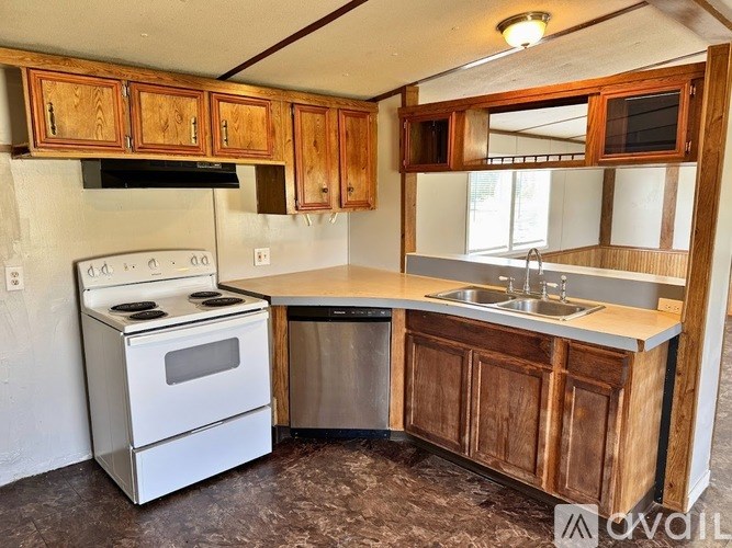 A kitchen with wooden cabinets and a white stove.