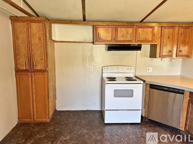 A kitchen with wooden cabinets and a white stove top oven.