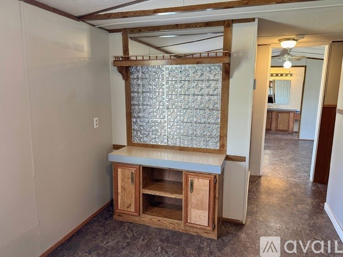 A wooden cabinet with a glass door is in the middle of a room.