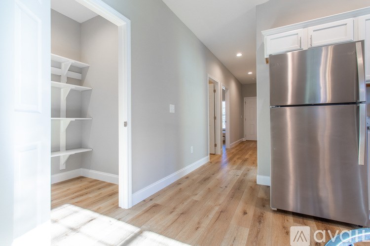 A kitchen with a stainless steel refrigerator and wooden floors.