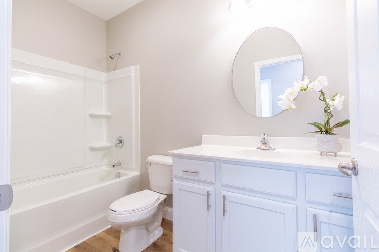 A white bathroom with a toilet, sink, and bathtub.