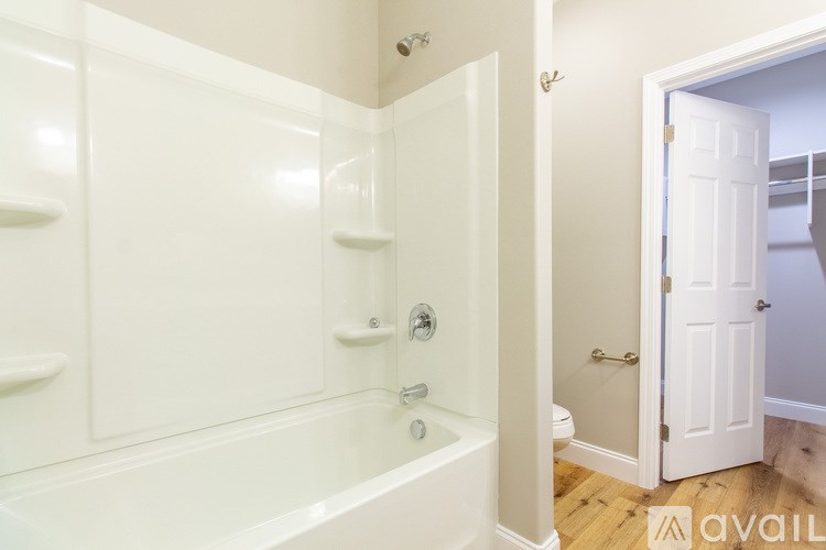 A white bathroom with a tub and toilet.