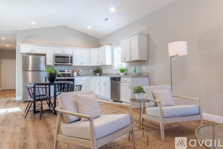 A modern kitchen with white cabinets and a dining table with chairs.