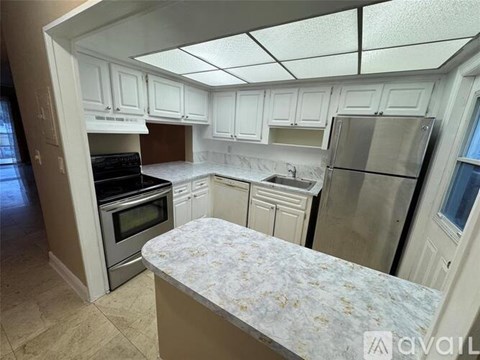 A kitchen with white cabinets and a marble countertop.