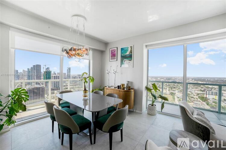 A dining room with a table set for six with a view of the city.