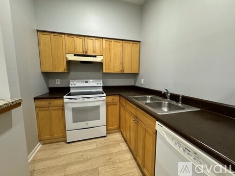 A kitchen with wooden cabinets and a white oven.