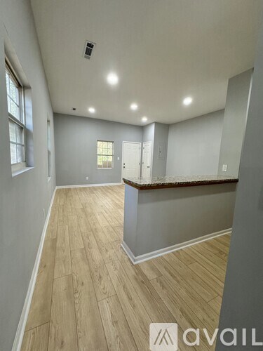 A room with wooden flooring and white walls.