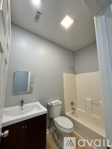 A white bathroom with a sink, toilet, and shower.