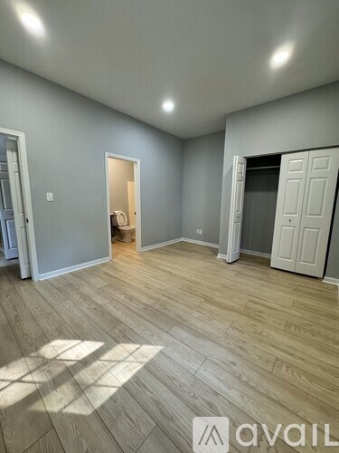 A room with wooden flooring and white doors.