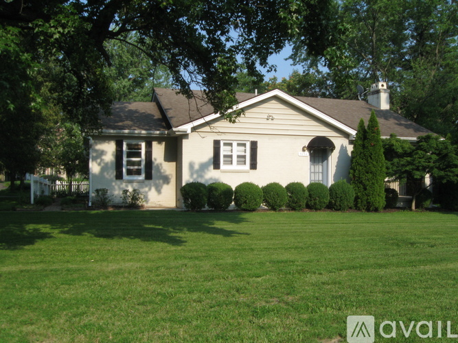 A house with a white fence and green lawn.