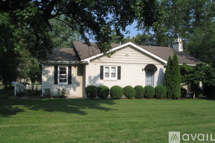 A house with a white fence and green lawn.