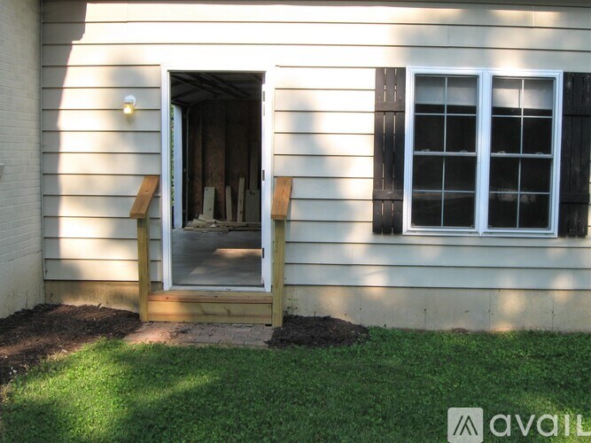 A house with a white door and window is available for rent.