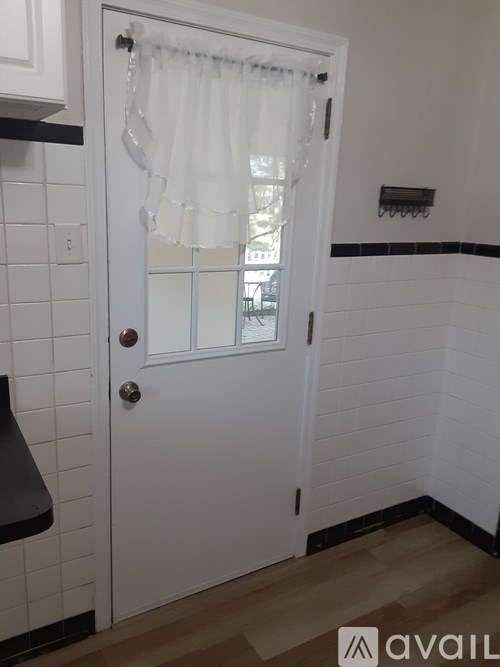 A white door with a window and a curtain.