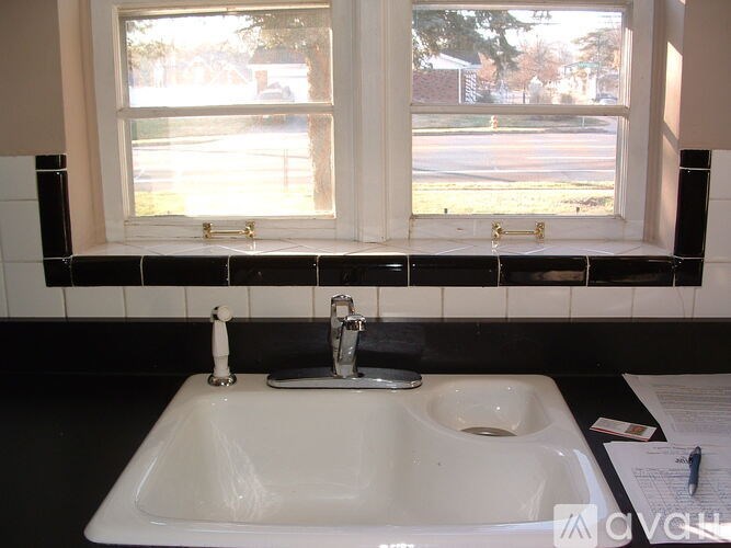 A white sink in a black and white tiled bathroom.