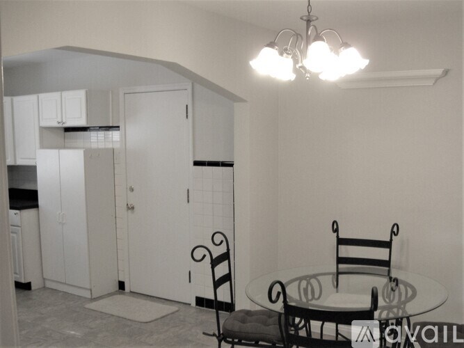 A kitchen with a table and chairs.