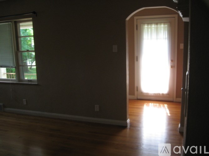 A room with a window and a door leading to another room.