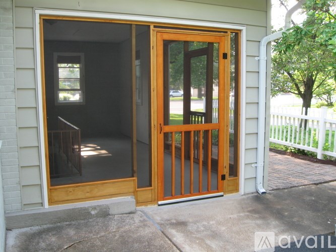 A wooden door with a glass window is open.